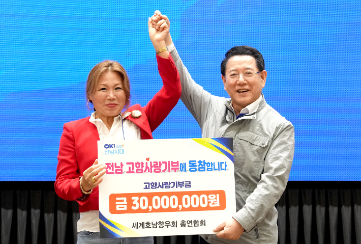 김영록 전라남도지사가 3일 오후 무안 남악 스카이웨딩컨벤션에서 열린 세계호남향우회총연합회 행사에서 이기자 총연합회장으로부터 고향사랑기부금을 전달받고 있다. 전라남도 제공