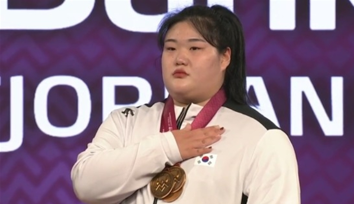 박혜정이 11일 노르웨이 푀르데에서 열린 2025 세계역도선수권대회 여자 86kg 이상급 경기에서 우승한 뒤 시상식dptj 애국가를 듣는 모습. 국제역도연맹 페이스북 캡처