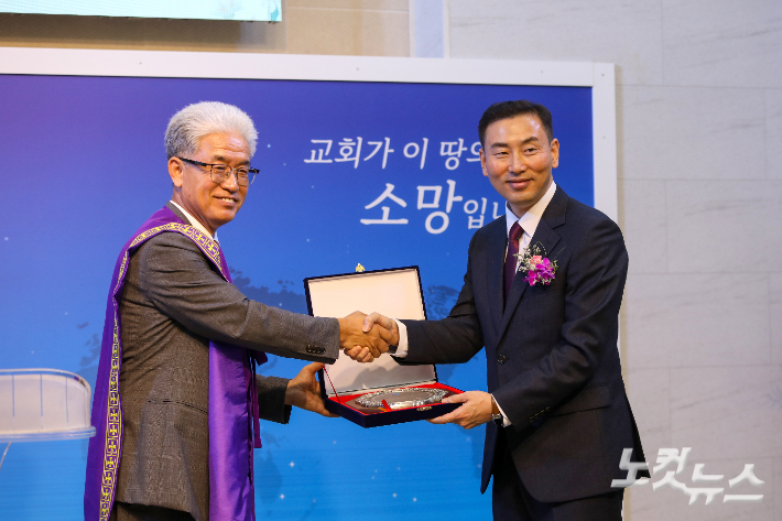 노회장 이종덕 목사(왼쪽)가 함인원 목사(오른쪽)에게 취임패를 전달하고 있다. 최화랑 기자