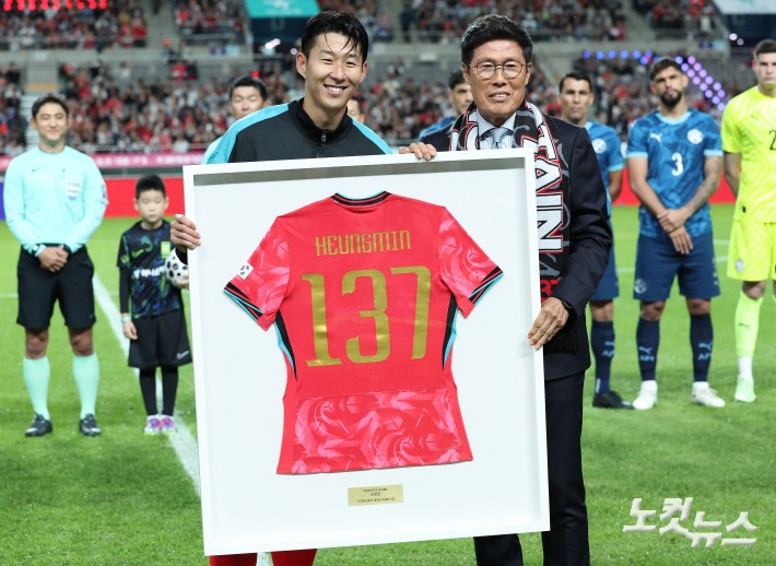 손흥민이 14일 서울 상암동 서울월드컵경기장에서 열린 축구 국가대표팀 친선경기 대한민국과 파라과이의 경기를 시작하기 전 차범근 전 감독에게 한국 남자 선수 A매치 최다 출전(137경기) 달성 기념 유니폼을 전달받고 있다.