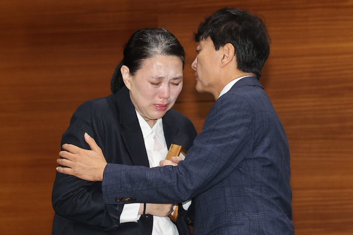 직장 내 괴롭힘을 호소하며 숨진 MBC 기상캐스터 오요안나 씨 어머니 장연미 씨가 15일 서울 마포구 상암동 MBC 사옥에서 고인의 명예사원증을 받은 뒤 눈물을 흘리고 있다. 연합뉴스