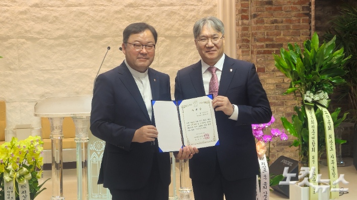 대한예수교장로회 통합총회 정훈 총회장(왼쪽)이 15일 서울 종로구 한국교회100주년기념관 그레이스홀에서 열린 총회 직원연합예배에서 최상도 사무총장에게 사령장을 전달하고 있다. 송주열 기자.