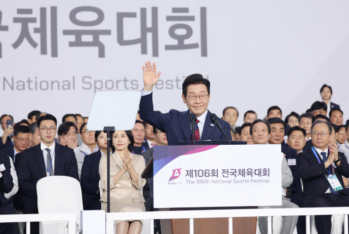 이재명 대통령이 17일 부산아시아드주경기장에서 전국체전 개막식 기념사를 위해 손을 들고 단상으로 향하고 있다. 연합뉴스