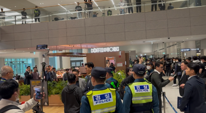 18일 오전 10시쯤  공항 입국장에서 한 남성이 송환자들의 이동 경로를 쫓아가다 경찰에 제지당하고 있다. 김수정 기자 