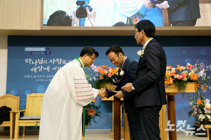 전주신상교회 박용호 목사가 두 원로장로에게 추대패를 전달하고 있다. 최화랑 기자