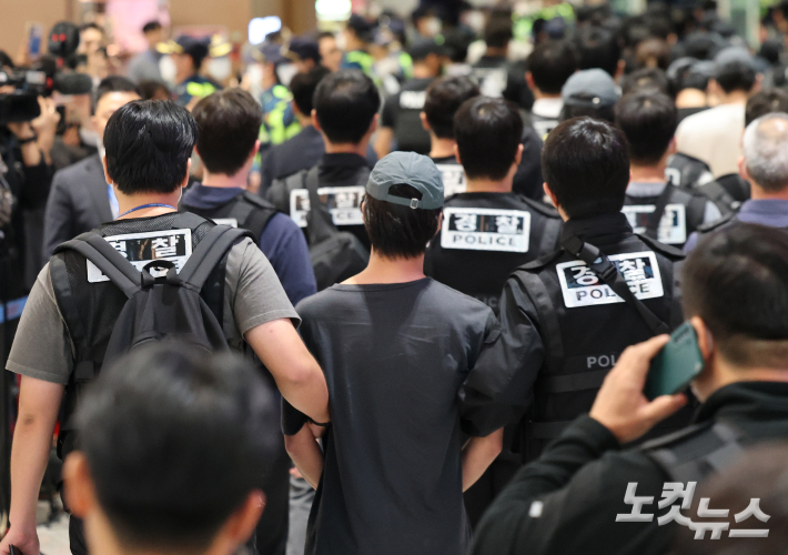 18일 인천국제공항 2터미널에서 캄보디아에서 범죄에 가담했다가 이민 당국에 구금된 한국인 64명이 국내로 송환돼 입국장으로 들어서고 있다. 인천공항=황진환 기자