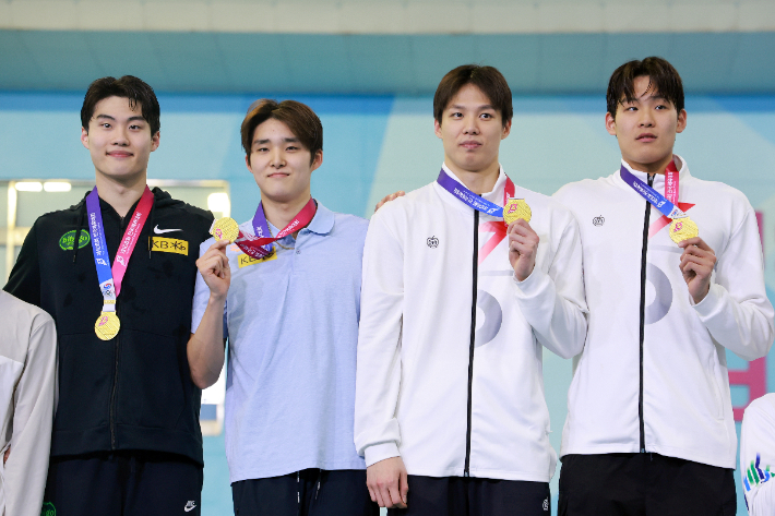 지난 19일 부산 아시아드주경기장에서 열린 제106회 전국체육대회 수영 남자 계영 800m에서 금메달을 딴 강원도청 선수들이 기념 촬영하고 있다. 사진 왼쪽부터 황선우, 김우민, 양재훈, 김영범. 연합뉴스 