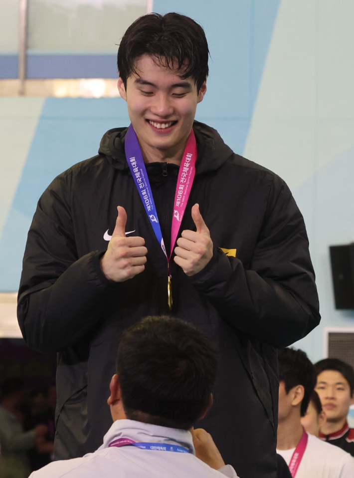 황선우(강원도청)가 20일 오후 부산 사직실내수영장에서 열린 제106회 전국체육대회 수영 남자 일반부 자유형 200m 결승 시상식에서 금메달을 목에 걸고 기뻐하고 있다. 연합뉴스
