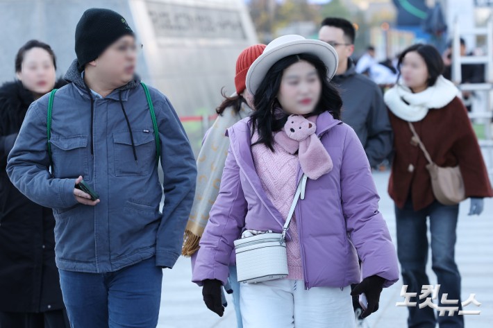 일부 지역에 올 가을 첫 한파주의보가 발효되는 등 초겨울 날씨를 보이는 27일 오전 서울 종로구 광화문네거리에 두꺼운 옷을 입은 관광객들이 발걸음을 재촉하고 있다.