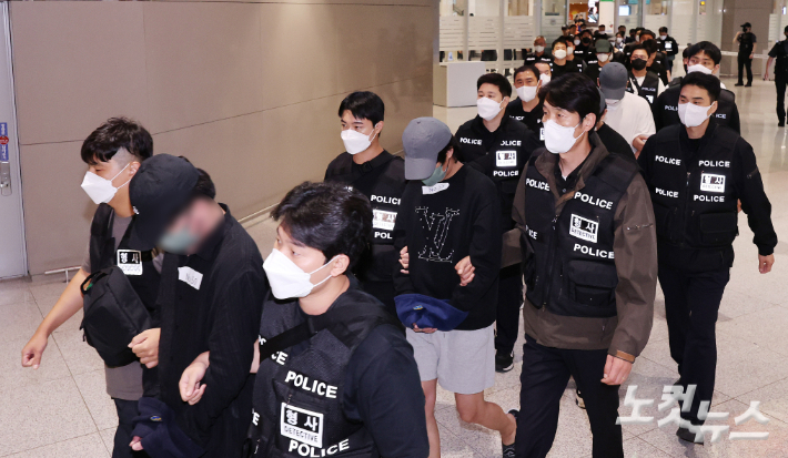 캄보디아 당국의 범죄단지 단속으로 적발돼 구금됐던 한국인들이 18일 오전 인천국제공항 2터미널을 통해 송환되고 있다.  이번 송환 대상자들은 이른바 '웬치'로 불리는 캄보디아 범죄단지에서 보이스피싱이나 로맨스 스캠(사기) 등 범죄에 가담한 혐의를 받고 있다. 이들은 호송 차량 23대 등을 타고 충남경찰청 등 6개 관할 경찰관서로 압송된다. 인천공항=황진환 기자