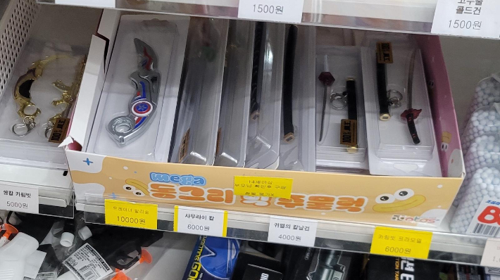 전북 익산의 한 초등학교 앞 무인문구점 매대에 진열된 '사무라이 칼', '귀멸의 칼날 검', '카림빗' 등 금속 재질 장난감 칼 제품들. 보배드림 캡처