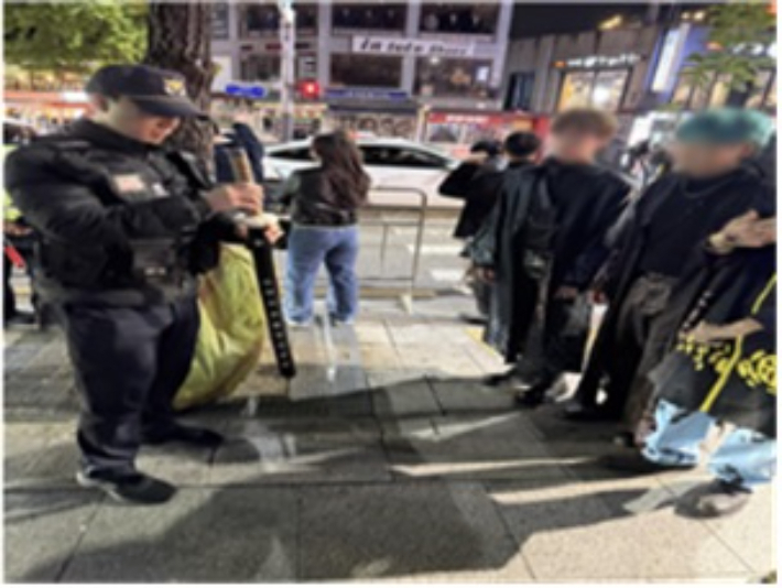 경찰이 지난 20일부터 23일까지 이뤄진 사전 범죄예방 진단 활동 중 서울 마포구 홍대 관광특구에서 모형 일본도를 들고 있는 사람을 검문검색하고 있다. 서울경찰청 제공