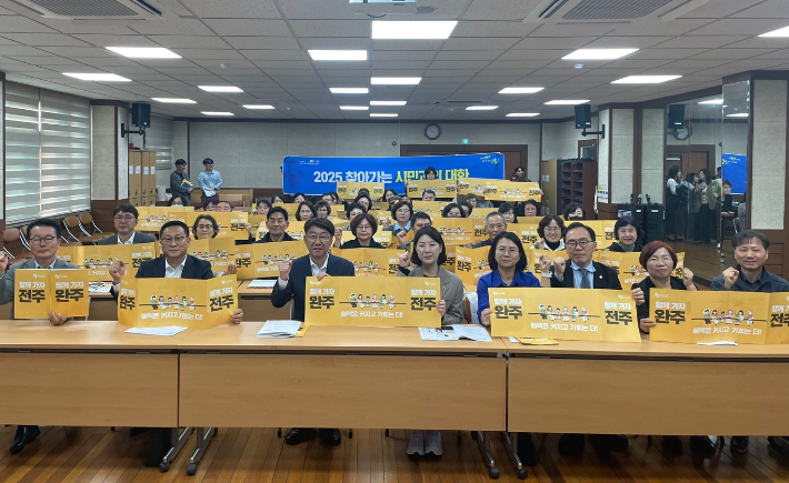 우범기 전주시장과 서난이 전북도의원, 지역주민들이 지난 28일 송천2동에서 열린 '2025 찾아가는 시민과의 대화'에서 완주-전주 통합을 염원하는 퍼포먼스를 하고 있다. 전주시 제공