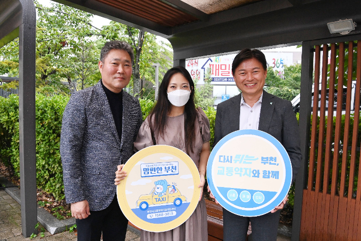 조용익(오른쪽) 부천시장이 맘(Mom)편한 택시를 이용하는 시민과 기념사진을 촬영하고 있다. 부천시 제공