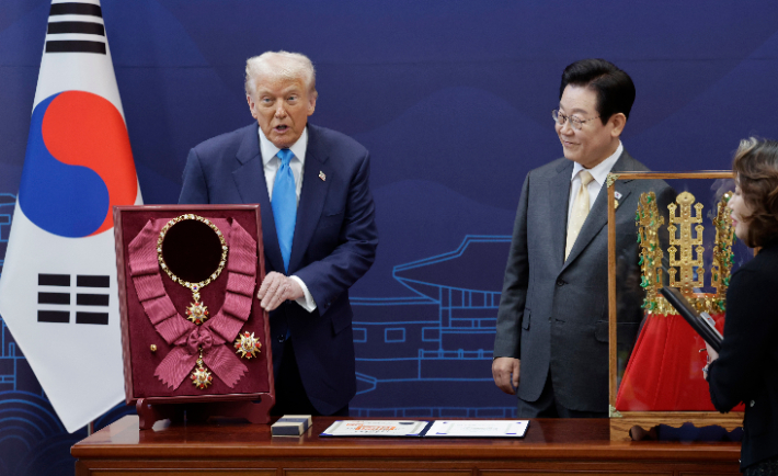 이재명 대통령이 29일 경북 경주박물관에서 도널드 트럼프 미국 대통령에게 '천마총 금관 모형'을 선물하며 설명하고 있다. 왼쪽은 이 대통령이 트럼프 대통령에게 수여한 무궁화 대훈장. 연합뉴스