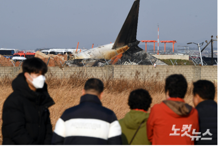 지난해 12월 29일 전남 무안국제공항에서 탑승객 181명을 태운 여객기가 착륙 중에 사고가 났다. 주민들은 사고 현장을 바라보고 있다. 황진환 기자