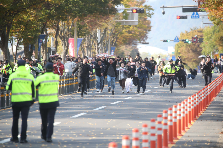 29일 오후 한미 정상회담이 열린 국립경주박물관 인근에서 도널드 트럼프 미국 대통령을 반대하는 기습 시위대가 경찰저지선을 뚫고 정상회담장으로 질주하고 있다. 연합뉴스