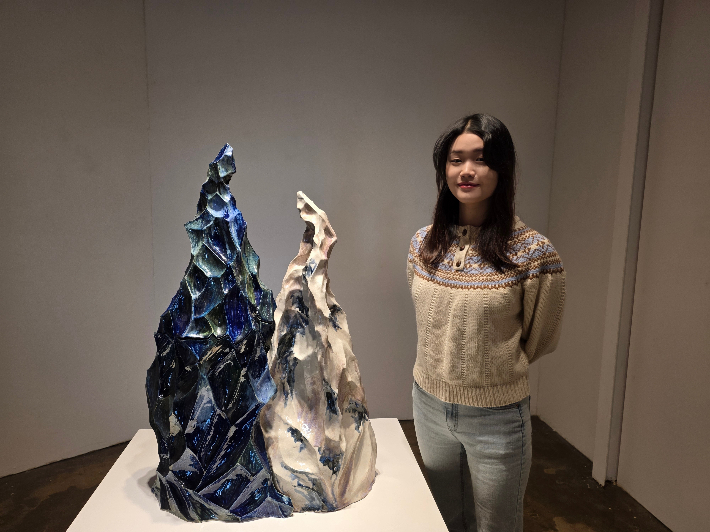 김지인 작가가 29일 첫 개인전 "흐르는 감정-위로의 파도"에 전시된 대표작 'Harmony(조화롭다)' 앞에서 포즈를 취하고 있다. 곽인숙 기자