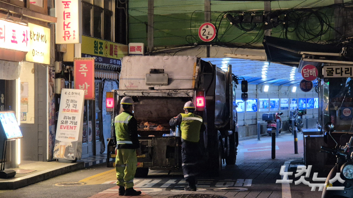 지난 21일 새벽 서울 용산구의 한 식당가 골목에서 환경미화원들이 생활폐기물 처리 작업을 하고 있다. 송선교 기자