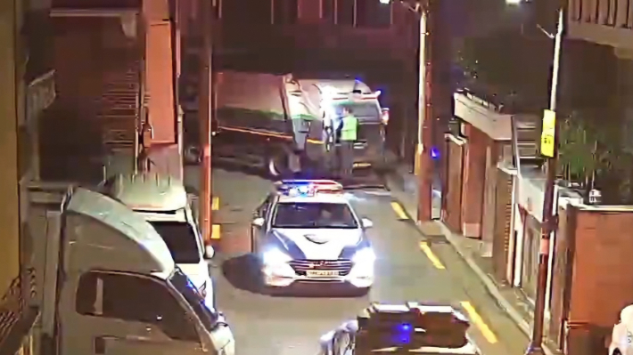 지난달 18일 새벽 서울 강서구 화곡동에서 쓰레기 수거차 후미에 매달린 상태로 작업하던 50대 환경미화원이 사고를 당해 구급차로 병원에 옮겨진 뒤 도착한 다른 작업자가 곧바로 사고 차량 후미에 매달려 이동했다. 서울 강서구의회 김민석 의원 제공 영상 캡처