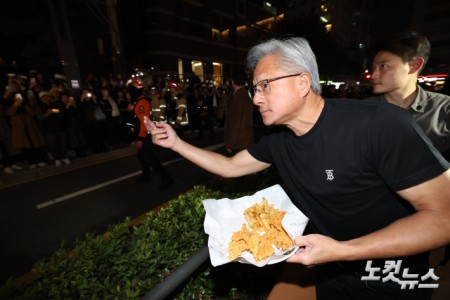 젠슨황 엔비디아 최고경영자가 30일 이재용 삼성전자 회장, 정의선 현대자동차그룹 회장과 서울 강남구 깐부치킨 매장에서 치킨 회동 중 밖으로 나와 시민들에게 치킨 등을 나눠주고 있다.