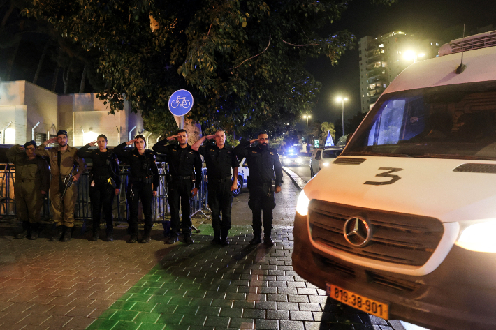 30일(현지시간) 시신 운구 차량에 경례하는 이스라엘 군경. 연합뉴스