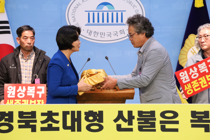 경북 초대형 산불 피해주민 대책위원회가 31일 국회에서 임미애 국회의원에게 '경북 초대형 산불 진상 규명을 위한 국정조사 실시 요구 성명서'를 전달하고 있다. 더불어민주당 경북도당 제공