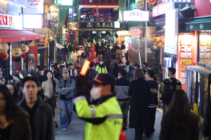 31일 서울 용산구 이태원 세계음식문화의 거리를 찾은 시민들이 중앙분리대를 따라 걸어가고 있다. 연합뉴스