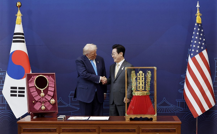 이재명 대통령이 29일 경북 경주박물관에서 도널드 트럼프 미국 대통령에게 '천마총 금관 모형'을 선물한 뒤 악수하고 있다. 연합뉴스