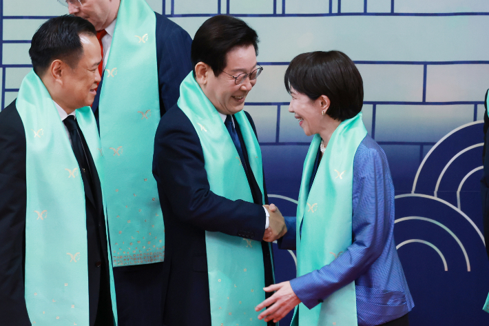 이재명 대통령이 1일 경주화백컨벤션센터(HICO)에서 열린 2025 아시아태평양경제협력체(APEC) 정상회의 기념촬영에서 다카이치 사나에 일본 총리와 인사하고 있다.  연합뉴스