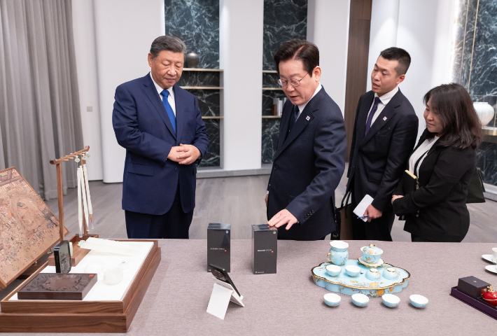 이재명 대통령과 시진핑 중국 국가주석이 1일 경북 소노캄 호텔에서 국빈만찬 전 갖은 친교 시간에 한중 정상이 서로를 위해 준비한 선물을 보고 있다. 연합뉴스