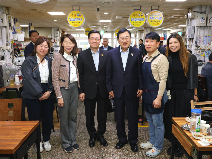 홍콩 존 리 행정수반 일행이 주낙영 경주시장과 함께 중앙시장 내 음식점에서 상인들과 기념촬영을 하고 있다. 경주시 제공