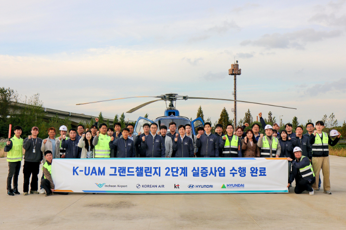 KT를 비롯한 현대자동차, 현대건설, 인천국제공항공사, 대한항공이 함께하는 K-UAM 원팀이 인천 아라뱃길 실증 현장에서 기념사진을 촬영하는 모습. KT 제공