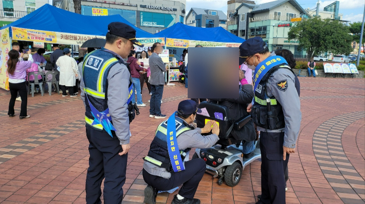장애인 휠체어에 야광반사 스티커를 부착하고 있다. 순천경찰서 제공