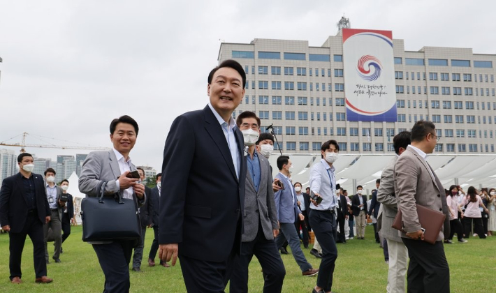 윤석열 전 대통령이 2022년 6월 19일 오후 용산 대통령실 청사 앞 잔디광장에서 열린 대통령실 이전 기념 주민 초대 행사에서 용산 지역 소상공인 참여한 플리마켓 부스를 둘러보며 미소짓는 모습. 연합뉴스