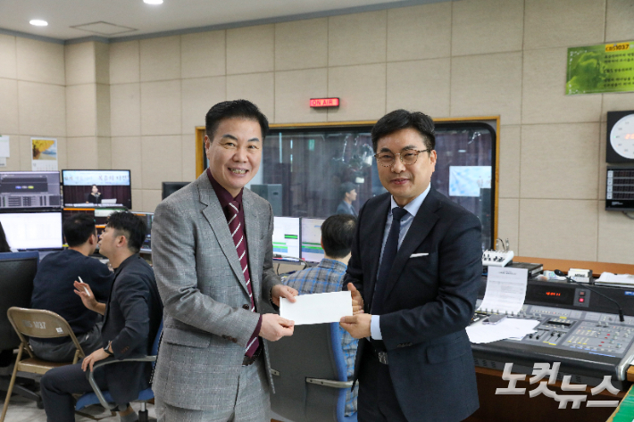 전북CBS 군산시운영이사장 고영완 목사(오른쪽)가 모금에 동참하며 헌금을 전북CBS 이균형 대표(왼쪽)에게 전달하고 있다. 최화랑 기자