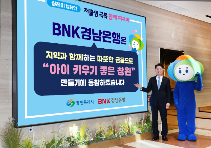 BNK경남은행 김태한 은행장이 창원의 캐릭터 '피우미'와 함께 '행복공동체 릴레이 캠페인'에 참여하고 있다. BNK경남은행 제공 
