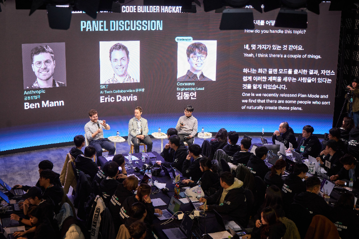 해커톤을 공동 개최한 SKT의 에릭 데이비스 AI 기술 협력 본부장(사진 앞줄 가운데)과 앤트로픽의 벤자민 맨 공동창업자(앞줄 왼쪽), 콕스웨이브의 김동언 엔지니어링 리드가 해커톤 참가자들 앞에서 AI 분야에 대한 패널 토론을 진행하는 모습. SKT 제공
