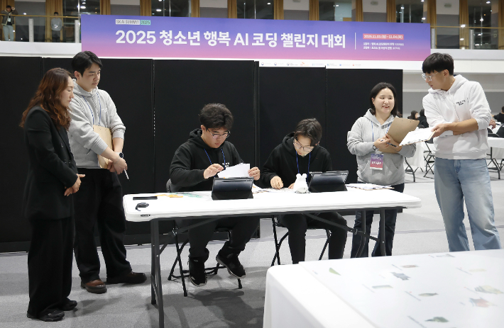 행복AI코딩챌린지의 미션챌린지에 참가한 청소년팀이 심사위원들 앞에서 AI로봇에 카드코딩을 하고 있는 모습. SKT 제공