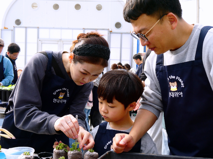 현대위아 임직원과 가족들이 지난 1일 경기도 이천시 포레스트벤처스 식물연구센터에서 오동나무 묘목을 분갈이하는 모습. 현대위아 제공