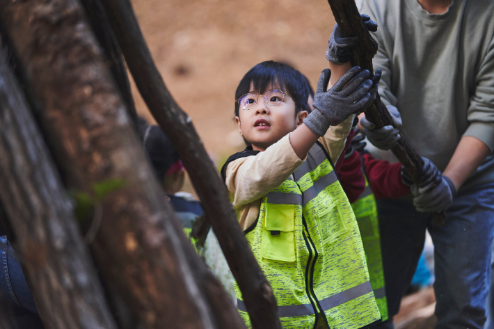 현대위아 임직원 가족이 지난 1일 경기도 이천시 포레스트벤처스 식물연구센터 생태숲에서 나뭇가지를 옮기며 고라니 쉼터를 만드는 모습. 현대위아 제공