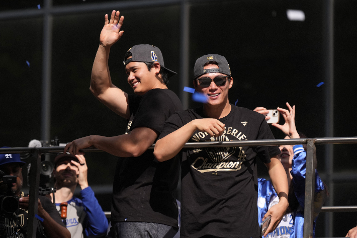 로스앤젤레스 다저스의 월드시리즈 우승에 공헌한 오타니(사진 왼쪽)와 야마모토가 4일(한국시간) 미국 캘리포니아주 로스앤젤레스 도심에서 열린 카퍼레이드 중 팬들에게 손을 흔들고 있다. 연합뉴스