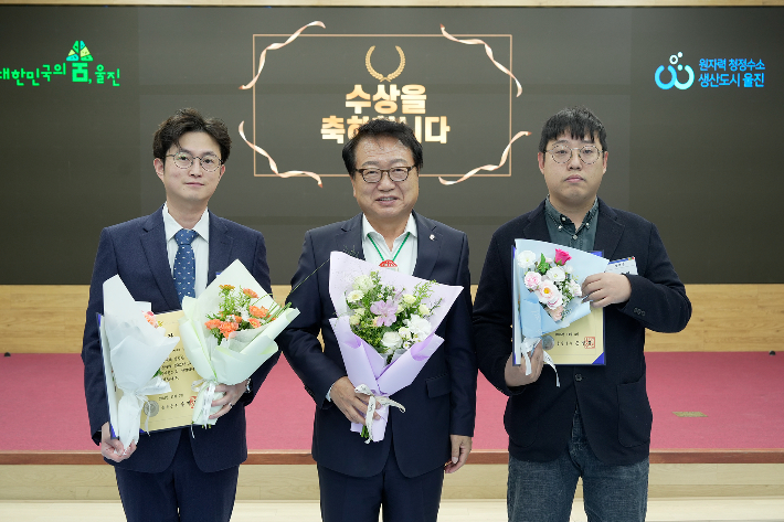 손병복(가운데) 울진군수가 민원행정 친절처리 우수공무원으로 선정된 죽변면 김민수 주무관과 평해읍 김상엽 주무관에게 상장을 전달한 뒤 기념사진을 촬영하고 있다. 울진군 제공