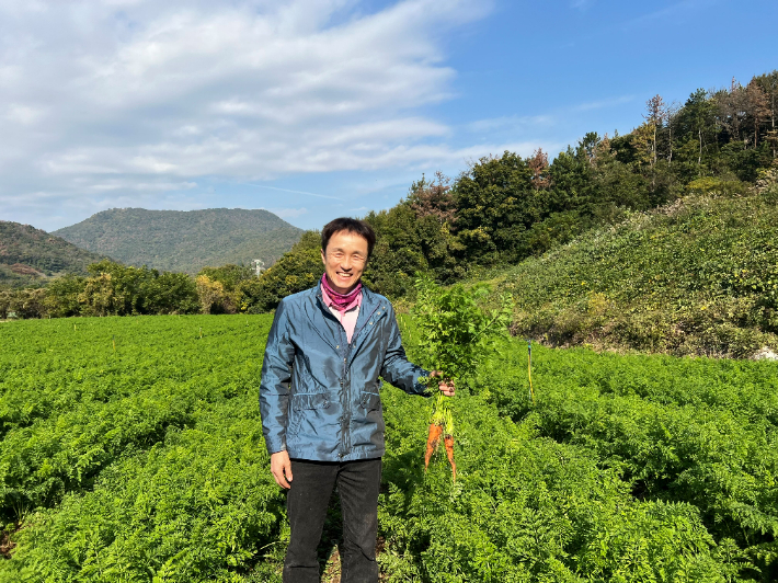 전남 11월 친환경 농산물로 선정된 무농약 당근을 재배하는 여수시 율촌면 류용현 씨가 당근을 들고 기념사진을 찍고 있다. 전라남도 제공