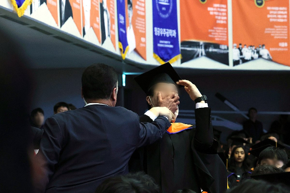 지난 2024년 2월 16일 대전 유성구 한국과학기술원(KAIST)에서 열린 2024년 학위수여식에서 한 졸업생이 윤석열 대통령이 축사를 할 때 R&D 예산과 관련해 자리에서 일어나 대통령을 향해 항의를 하던 중 제지를 당하고 있다. 연합뉴스