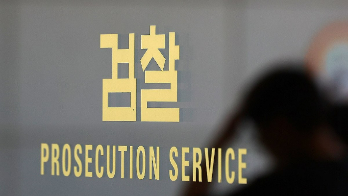 5일 서울 서초구 서울중앙지검 검찰 로고에 직원의 모습이 비치고 있다. 연합뉴스