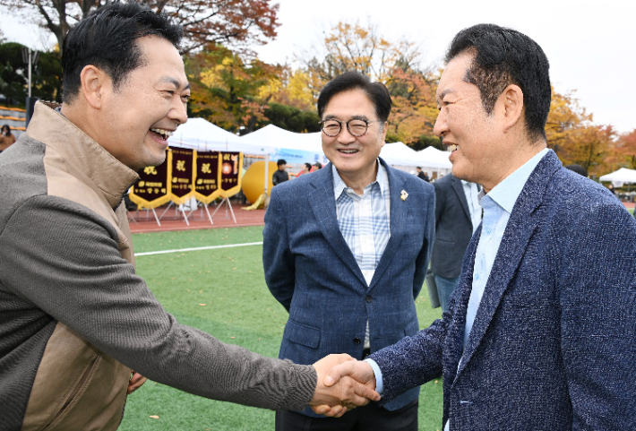 더불어민주당 정청래 대표와 국민의힘 장동혁 대표가 8일 서울 여의도 국회의사당 운동장에서 한국사진기자협회가 연 '2025 사진기자가족 체육대회'에 방문해 인사하고 있다. 가운데는 우원식 국회의장. 연합뉴스