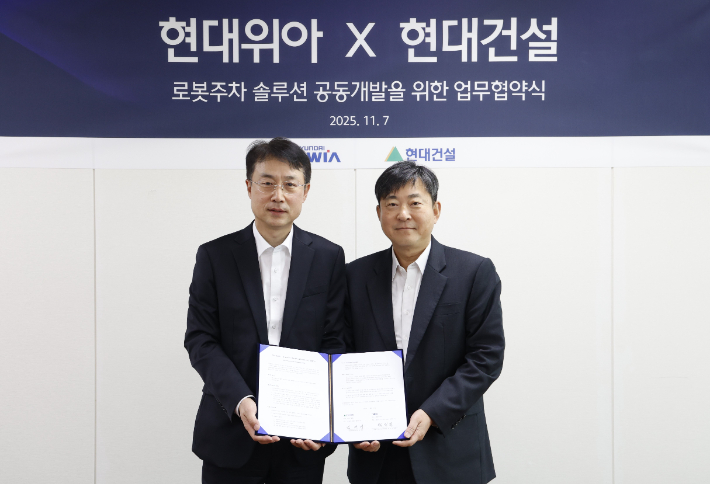 현대위아 모빌리티솔루션사업부 백익진 상무(왼쪽)와 현대건설 기술연구원 김재영 원장이 7일 경기도 의왕시 현대위아 의왕연구소에서 열린 '로봇 친화형 주차솔루션 공동개발을 위한 업무협약식'에서 기념 사진을 찍고 있다. 현대위아 제공