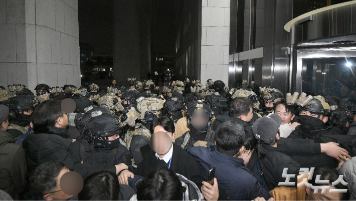 지난 2024년 12월 4일 새벽 서울 여의도 국회에서 경내로 진입하려는 계엄군과 저지하려는 시민 및 국회 관계자들이 대치하고 있다. 박종민 기자