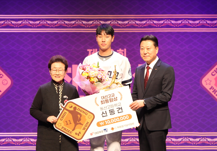 대선주조 최성욱 본부장(오른쪽)이 김정자 여사(고 최동원 선수의 어머니)와 함께 제8회 대선 고교 최동원상 수상자 동산고 신동건(가운데)과 기념 촬영을 하고 있다. 대선주조 제공 